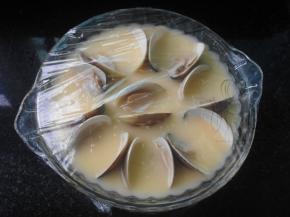 把蛤蜊摆在蒸碗里；倒入过滤后的蛋液；包上保鲜膜用牙签戳几个小洞