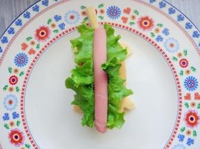 将洗净的生菜叶和香肠在开口中摆好