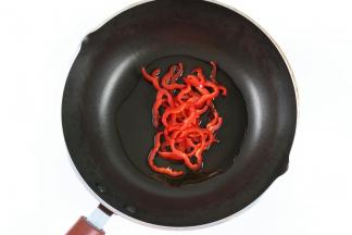 炒锅中加入适量的橄榄油，加入红椒，小火炒出香味。