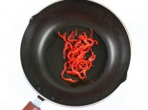 炒锅中加入适量的橄榄油，加入红椒，小火炒出香味。