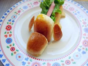 另取一个面包，从中间纵向切开，一半是嘴巴，一半是头部，并用中间多余的一小块面包皮刻出耳朵，摆在相应的位置