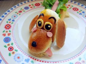 用海苔和奶酪片刻出眼睛，眉毛，蘸少许沙拉酱粘在相应的位置。一粒黑提子干做鼻头，再在背部的香肠上挤上沙拉酱就可以了。