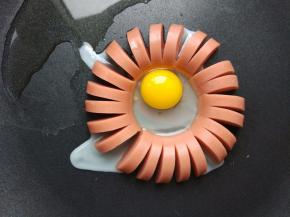 红色香肠也是如此处理。如果锅底不热，打入鹌鹑蛋后，底部不能马上凝固，会流到香肠外面去的