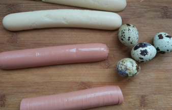 香肠去皮，从中间纵向剖开。准备几个生的鹌鹑蛋。香肠最好不要选太粗或者真空包装的。