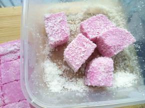 容器里撒椰蓉，把火龙果牛奶糕放椰蓉里滚滚