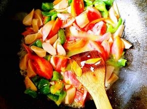 待上一步的食材变软之后，就可以放入西红柿了，继续煸炒，时间不必过长，西红柿能够淅出红汤即可。