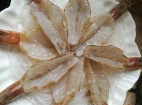 粉丝用剪刀剪成数段，铺在盘子底部，上面放上开背虾。