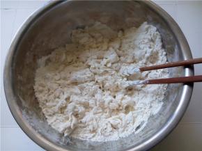 慢慢的加入，用筷子搅拌成松散的颗粒状。
