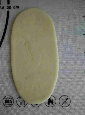 取松弛好的面团轻轻擀成牛舍状