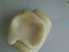 取松弛好的面卷，大拇指在中间按一下