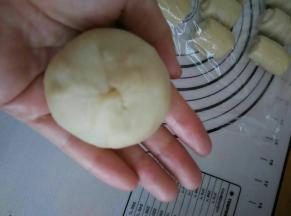 擀成面皮，把蛋黄包裹好。用虎口慢慢往上推，不停的转动，最后捏紧收口朝下