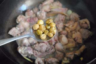 炒至鸭块微干放入料酒，胡椒粉和山黄皮