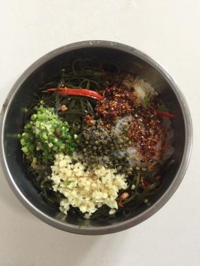 把沥干水分的海带尖椒丝，粉丝放进大盆子里，放入蒜蓉，葱花，新鲜的花椒碎，辣椒油，香醋，生抽，盐，鸡精，香油！