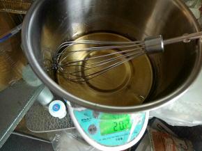 将拌匀的糖浆里面加入一半的花生油，慢慢的画圈拌匀。