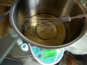 将拌匀的糖浆里面加入一半的花生油，慢慢的画圈拌匀。