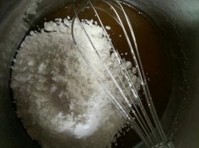 将6中的糖浆里面加入方子一半的面粉。拌匀。