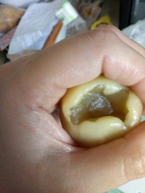 将醒发好的面糊，拿出来，放入剩下的一半面粉，用刮刀拌匀，就可以用了。称17克月饼皮，用虎口收口法包白莲蓉蛋黄馅。