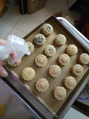 烤箱200预热。用喷壶在月饼上均匀的喷一层水汽。