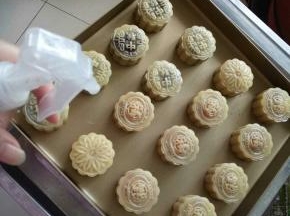 烤箱200预热。用喷壶在月饼上均匀的喷一层水汽。