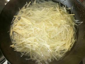 将泡好的土豆丝放入烧开的水中焯一下，直至水再次沸腾，大概2.3分钟左右就可以关火。捞出来放入凉水中投几次，然后控干水分准备材料就可以拌了。