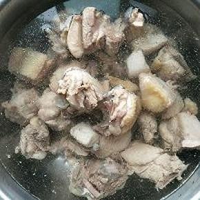 捞出的鸡块用清水清洗干净，砂锅内放入足量的水，冷水下入鸡块。