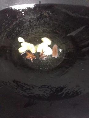 锅里少许油烧热，煸香八角、桂皮、姜蒜，推到炒锅一侧。