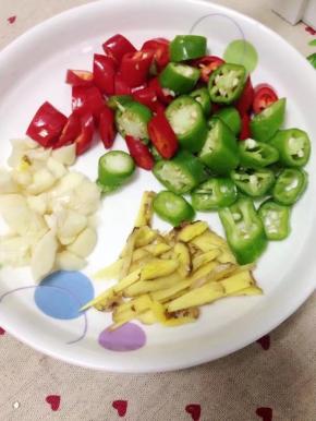 把青红辣椒洗净切小段，姜切丝，大蒜略拍。