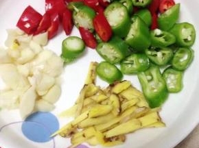 把青红辣椒洗净切小段，姜切丝，大蒜略拍。