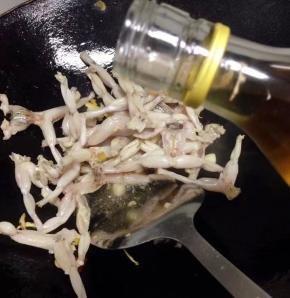 加入清冼净的青蛙肉，倒入少许料酒翻炒（料酒去腥 ）。