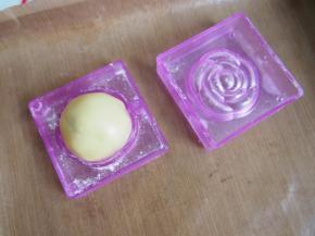 模具上面撒上一层面粉，将面团放入模具中，阳晨和果子的这款模具比较小巧，所以只能包半个咸蛋黄呢~模具做冰皮月饼也是蛮不错的哦~