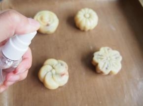 将压好的月饼放在烤盘上，烤箱预热到160度，喷上一层清水，烘烤5分钟定型