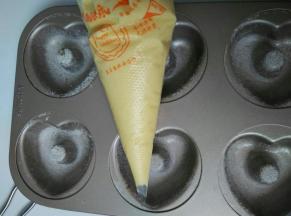 面糊装入裱花袋里挤入模具中，半分满时撒上蔓越莓干，再挤满面糊