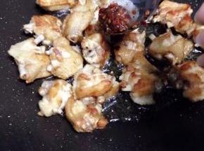 鸡翅表皮微黄干焦以后、加入2勺豆瓣酱、翻炒均匀、中小火炒入味、