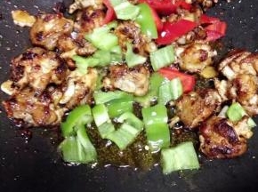 然后加切好的青椒和红椒块继续跟鸡肉一起翻炒均匀入味即可出锅。