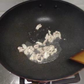 锅里倒入油，把切好的猪肉加入翻炒变色后放入蒜炒香