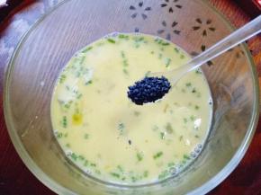 打散的鸡蛋里加入熟黑芝麻，搅拌均匀。