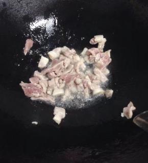 锅里倒入油，加入切好的猪肉加少许盐翻炒。