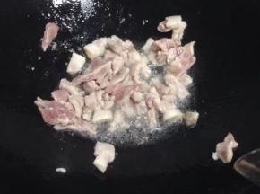 锅里倒入油，加入切好的猪肉加少许盐翻炒。