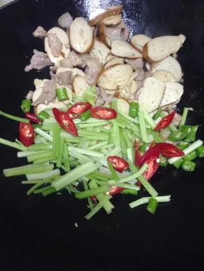 把青红椒、芹菜一起加入大火翻炒