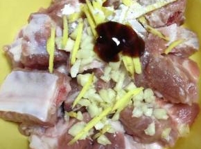 把排骨捞出在盘里，姜切丝，大蒜略拍剁碎放到排骨里，加入耗油、淀粉、油、盐拌匀，腌制10分钟