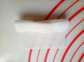 将馄饨皮的一端对折。