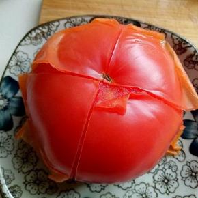 首先将番茄去皮，沸水中煮2分钟，捞出后皮很容易剥掉，如图。