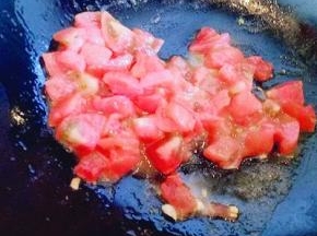 锅中加入少量油，倒入切好的番茄煸炒，炒至番茄炒软。