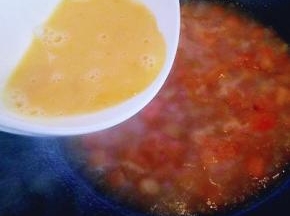 锅中的番茄烧开后，洒入蛋液(鸡蛋用画圈的手势倒入锅中，切记不要一下子把鸡蛋液倒入锅中。)拿着碗围绕锅的一圈慢慢倒入。