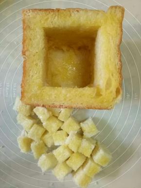 把掏空的吐司里和边缘，面包丁都刷上黄油蜂蜜液