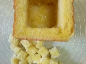 把掏空的吐司里和边缘，面包丁都刷上黄油蜂蜜液