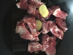 锅里煮开水后放入猪尾骨和两片姜片焯去血水