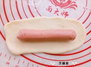 取一份面团擀开，放一个烤肠。卷好，摆在阳晨金色烤盘里。进行二次发酵。（有船型纸托的可以放进纸托里烤出来的形状会更好看）