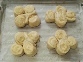 烤盘垫油纸放在上面用手轻压一下扁一点，不至于发酵完成会很鼓。送入微波炉中进行最后发酵（放一碗热水以增加湿度）。