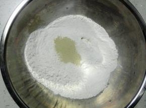 面粉放入盆中，加入酵母拌匀